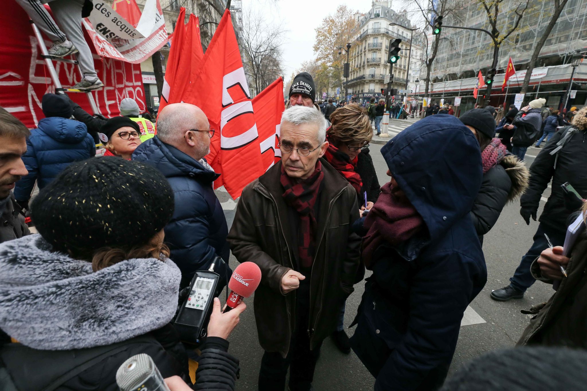 Secretary-General of the French Union Force Ouvriere (FO) Yves Veyrier (C) talks with the press during a demontration to protest against the pension overhauls, in Paris, on December 5, 2019 as part of a national general strike. Trains cancelled, schools cl Secretary-General of the French Union Force Ouvriere (FO) Yves Veyrier (C) talks with the press during a demontration to protest against the pension overhauls, in Paris, on December 5, 2019 as part of a national general strike. Trains cancelled, schools cl