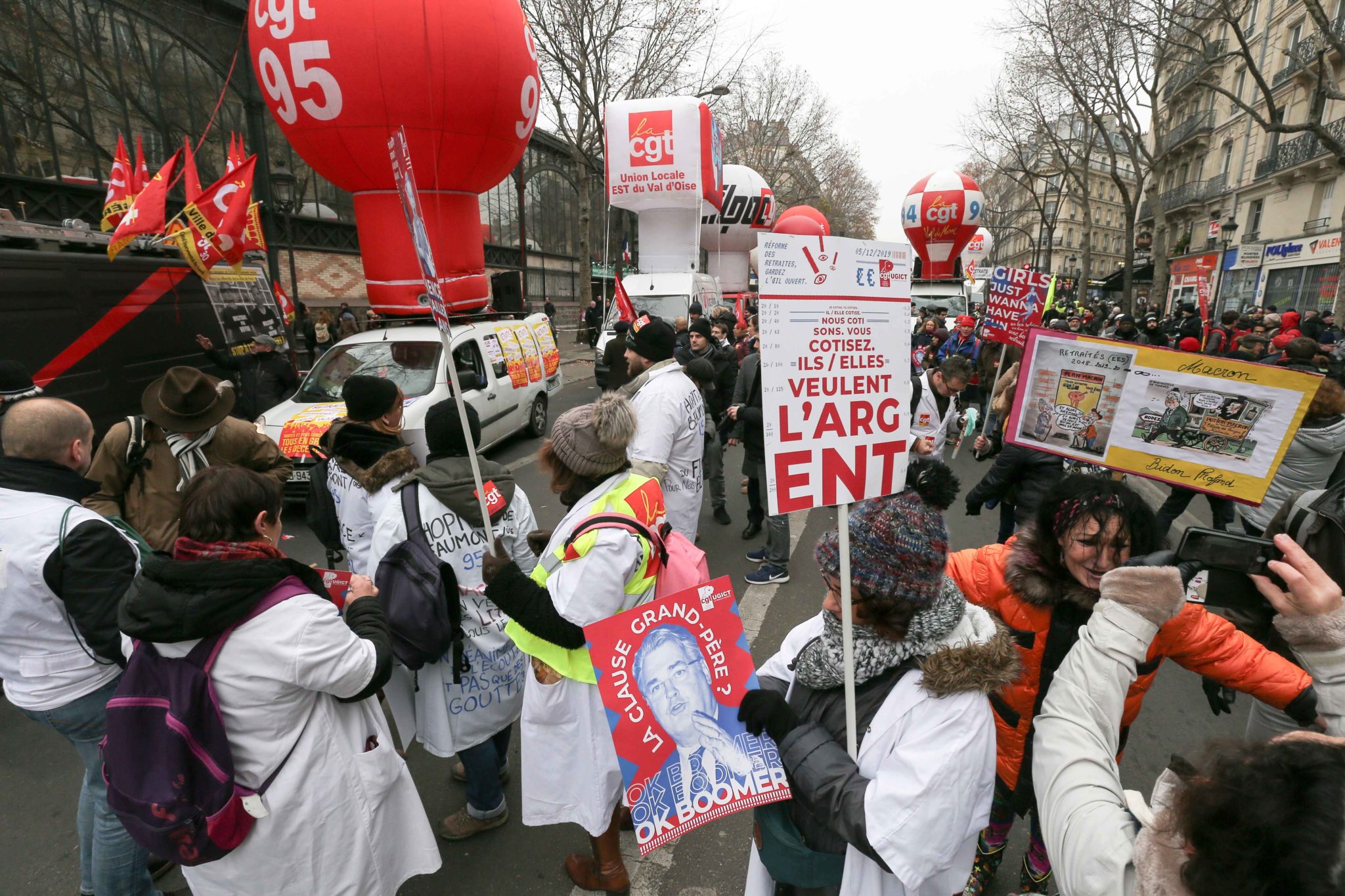Protesters hold signs during a demontration to protest against the pension overhauls, in Paris, on December 5, 2019 as part of a national general strike. Trains cancelled, schools closed: France scrambled to make contingency plans on for a huge strike agai Protesters hold signs during a demontration to protest against the pension overhauls, in Paris, on December 5, 2019 as part of a national general strike. Trains cancelled, schools closed: France scrambled to make contingency plans on for a huge strike agai
