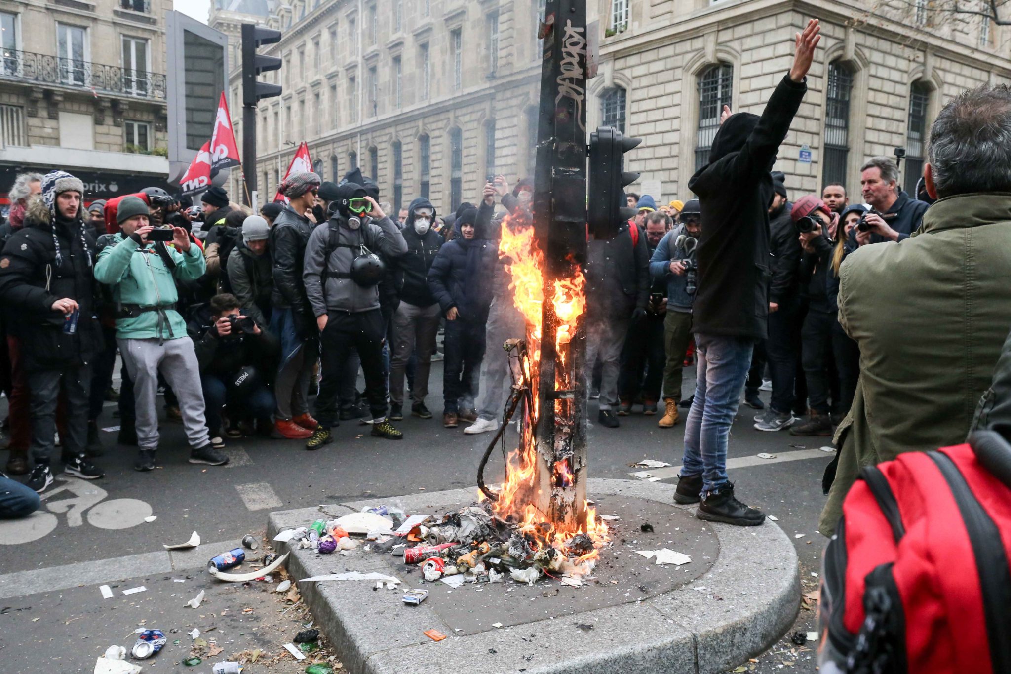 Protesters burn a traffic sign post during a demontration to protest against the pension overhauls, in Paris, on December 5, 2019 as part of a national general strike. Trains cancelled, schools closed: France scrambled to make contingency plans on for a hu Protesters burn a traffic sign post during a demontration to protest against the pension overhauls, in Paris, on December 5, 2019 as part of a national general strike. Trains cancelled, schools closed: France scrambled to make contingency plans on for a hu