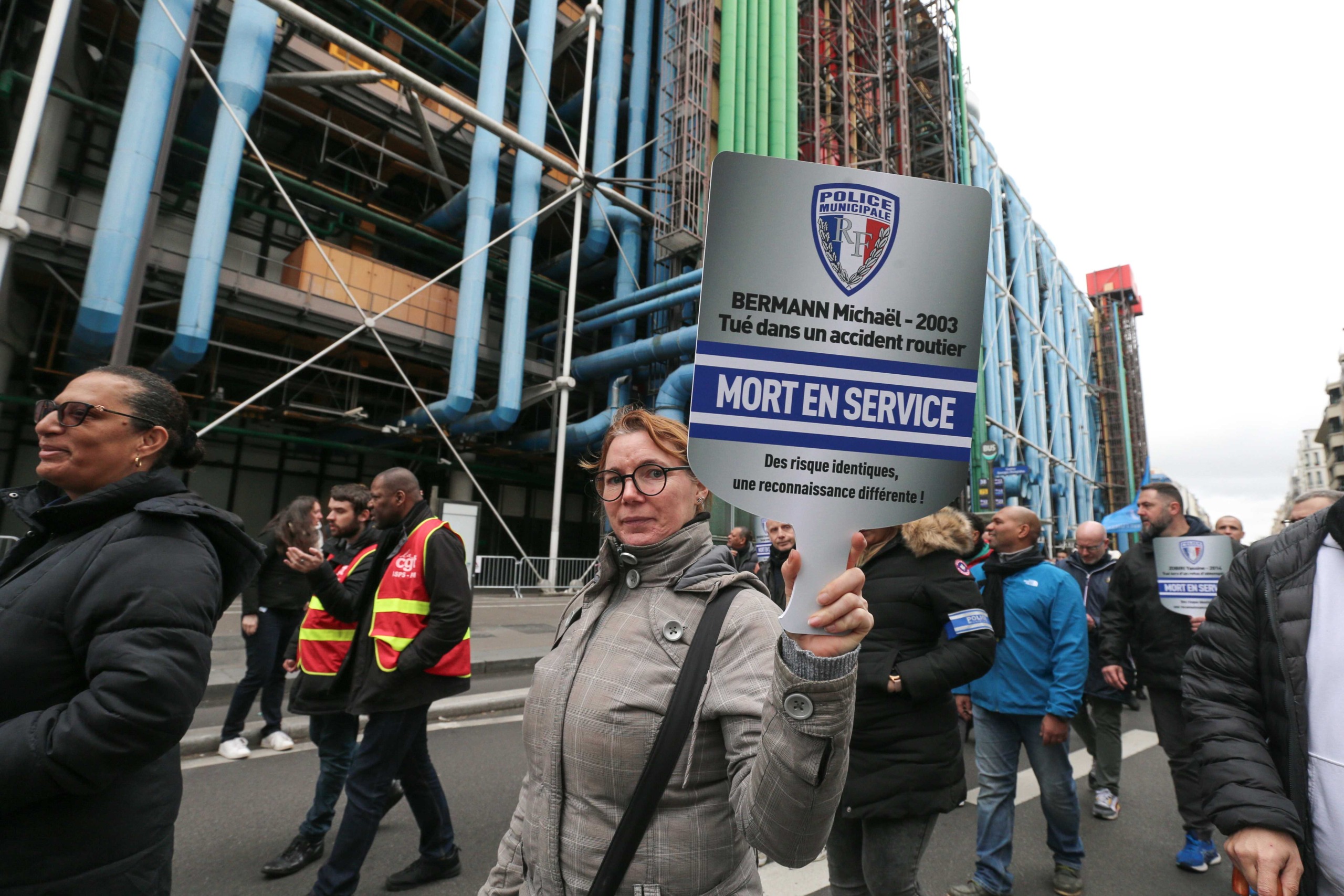 A protester holds a sign with the name of a police officer who died in the line of duty during a demonstration of municipal police in Paris on February 3, 2024, as part of a nationwide movement launched by the "collective of angry municipal police officer A protester holds a sign with the name of a police officer who died in the line of duty during a demonstration of municipal police in Paris on February 3, 2024, as part of a nationwide movement launched by the "collective of angry municipal police officer